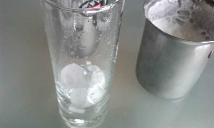 在杯中加入少量冰块，将牛奶倒入后再加上奶泡。