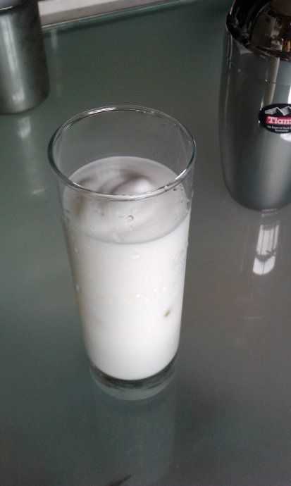 在杯中加入少量冰块，将牛奶倒入后再加上奶泡2