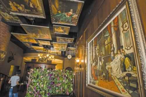 丽岙一家咖啡吧里，天花板和墙壁上挂满了西方画。