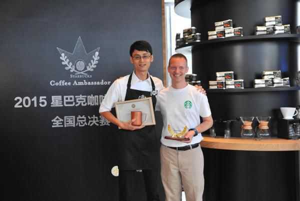 星巴克中国营运副总裁JeffMiller（右）为星巴克中国拿铁艺术冠军于卓颁奖（左）