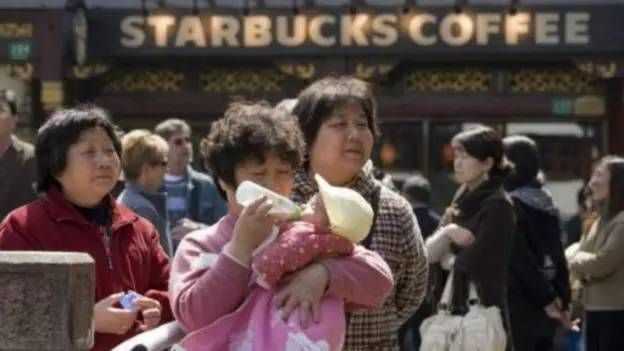 一位女士在上海豫园星巴克外给宝宝喂奶