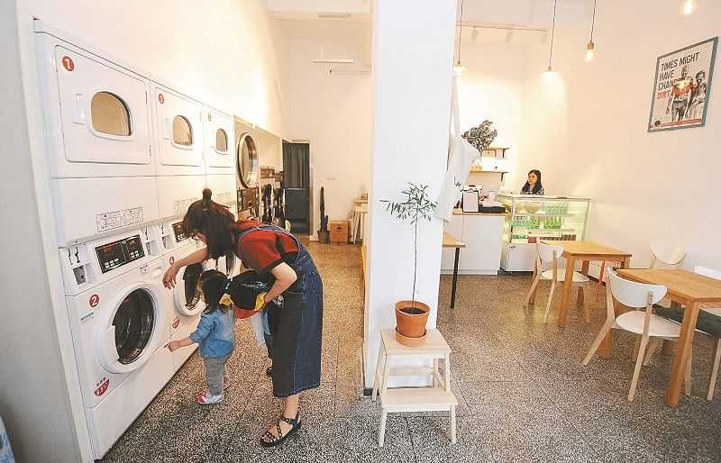 来自广东的旅行者闫女士带着她的孩子来店里洗衣服，边喝咖啡边等衣服烘干。
