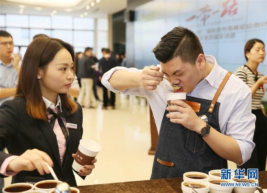 在重庆咖啡交易中心，一名咖啡师（右）在演示如何啜吸
