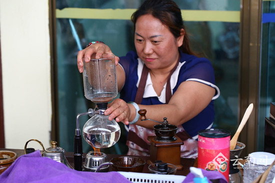 百花岭村的党支部书记杨成吴的妻子在制作咖啡