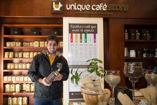 在位于巴西圣洛伦索市中心的咖啡店内，佩雷拉家族的第四代成员、咖啡店经营者艾尔西奥手持咖啡商品留影