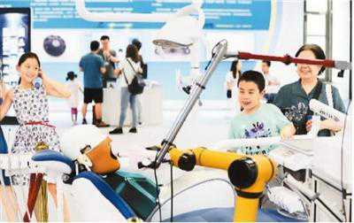 6月15日，在北京中关村举行的全国大众创业万众创新活动周上，家长带着孩子参观口腔临床微机器人手术系统。