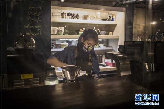 伊朗德黑兰一家咖啡馆的工作人员戴着口罩工作