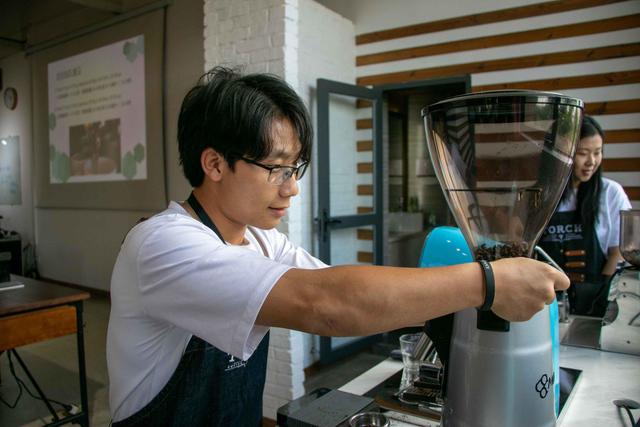 云南省普洱市炬点咖啡实验室咖啡师正在研磨咖啡